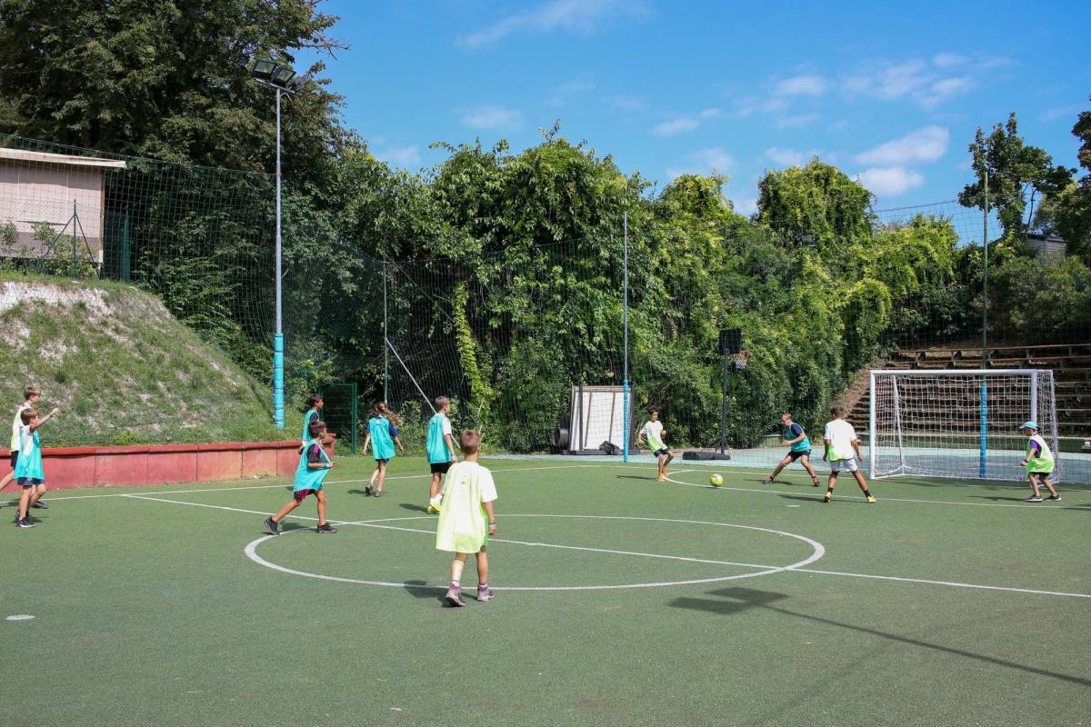 Gruppe von Kindern spielt Fußball auf dem Campingplatz