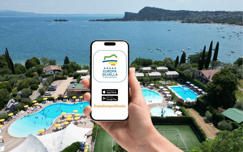 Hand hält ein Smartphone mit dem App Symbol von Enjoy Europa Silvella
