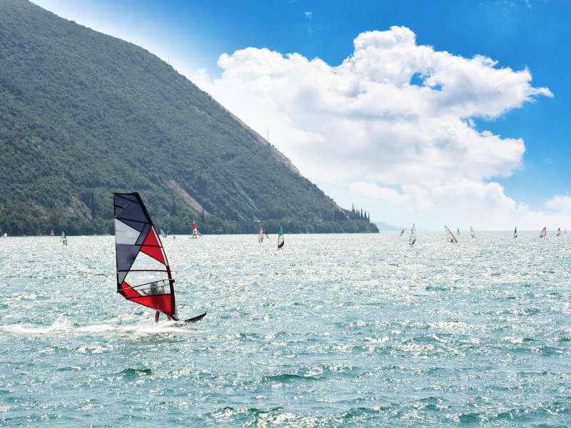Eine Person beim Windsurfen auf dem Gardasee